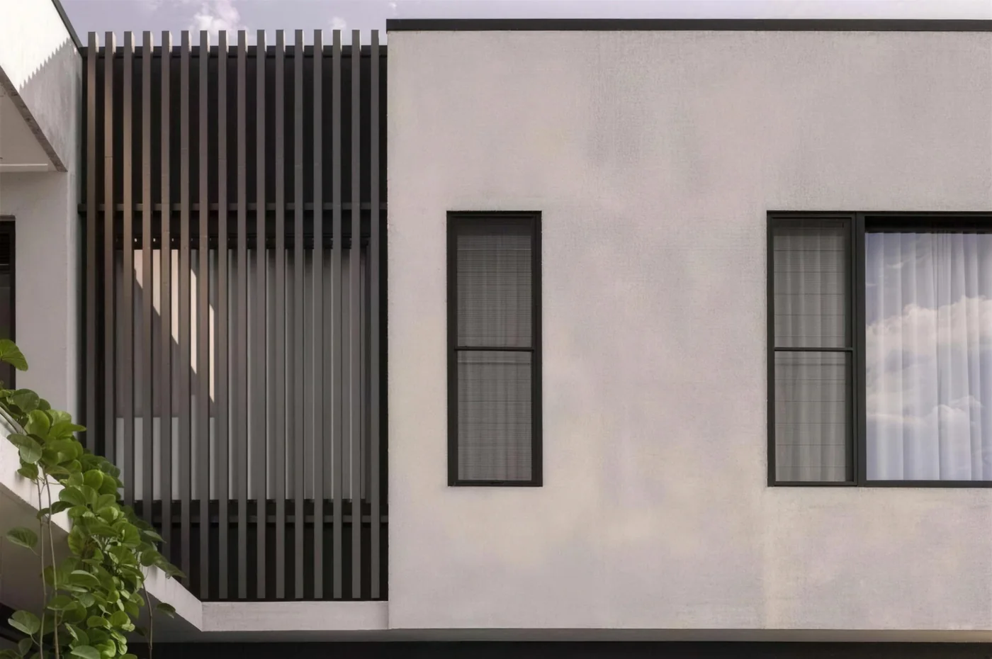 Modern home exterior with grey cladding and dark timber battens