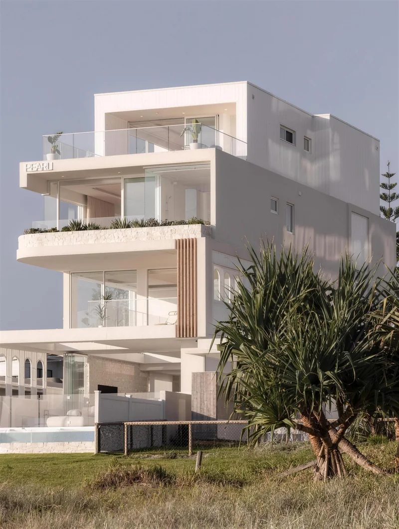 White rendered beach house with a pandanus out front