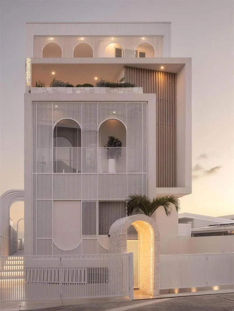 White arched facade with vertical battens at dusk