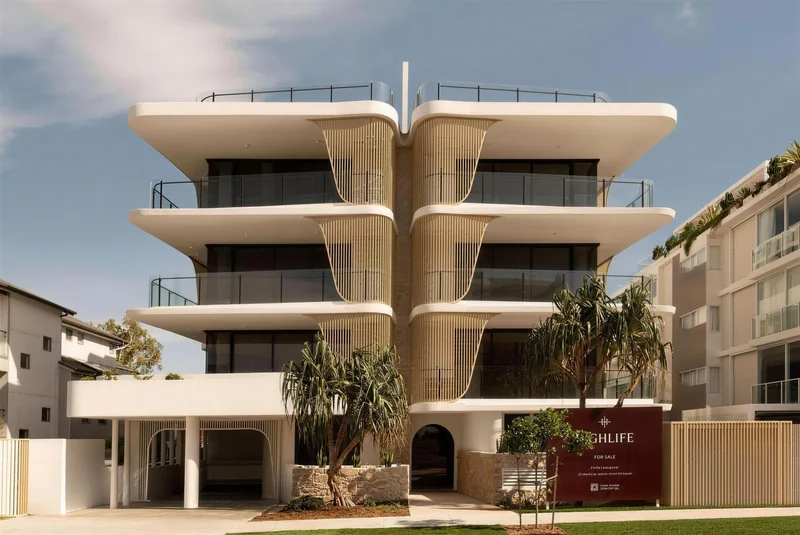 Apartment building with curved gold screens and white render