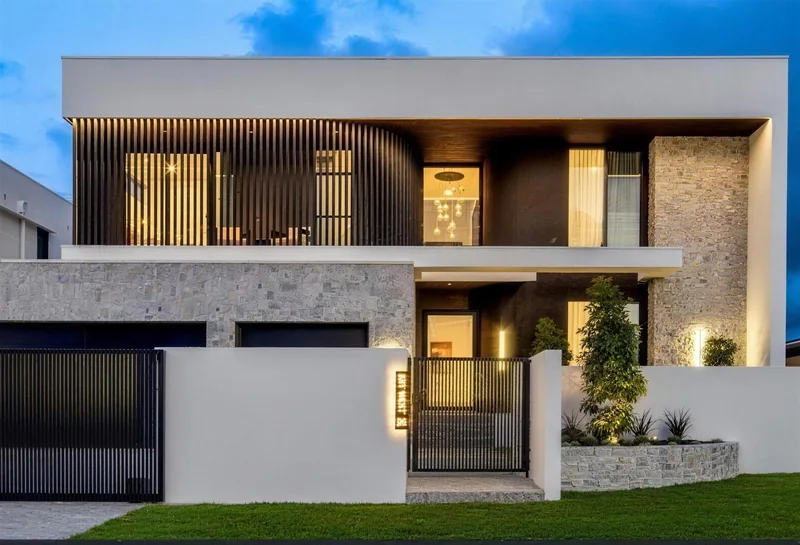 Two-storey rendered home lit at dusk